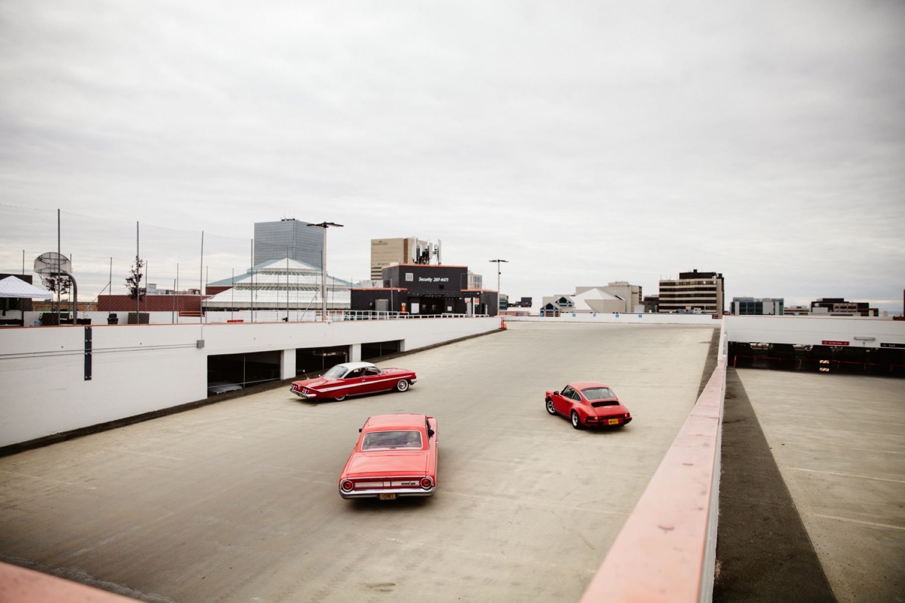 three red vintage cars assemble at easy park garage