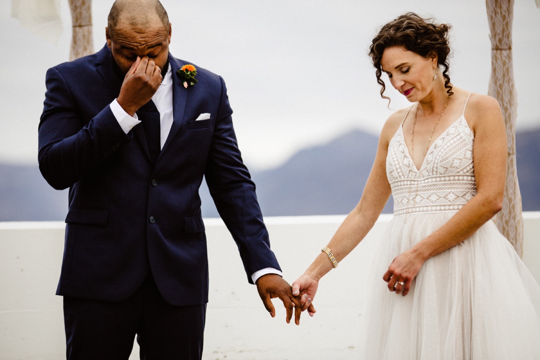 groom wipes away tears during wedding prayer