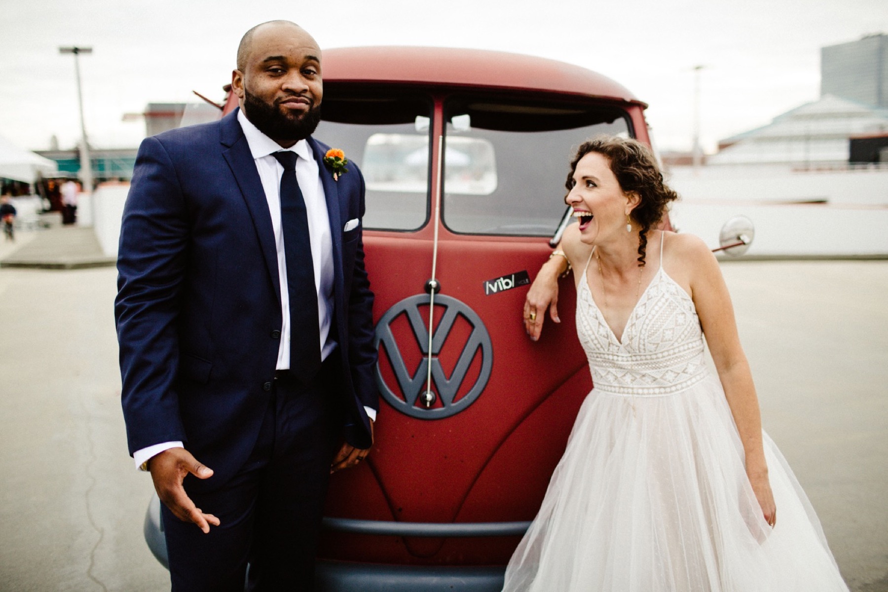bride and groom stand in front of a vintage VW bus
