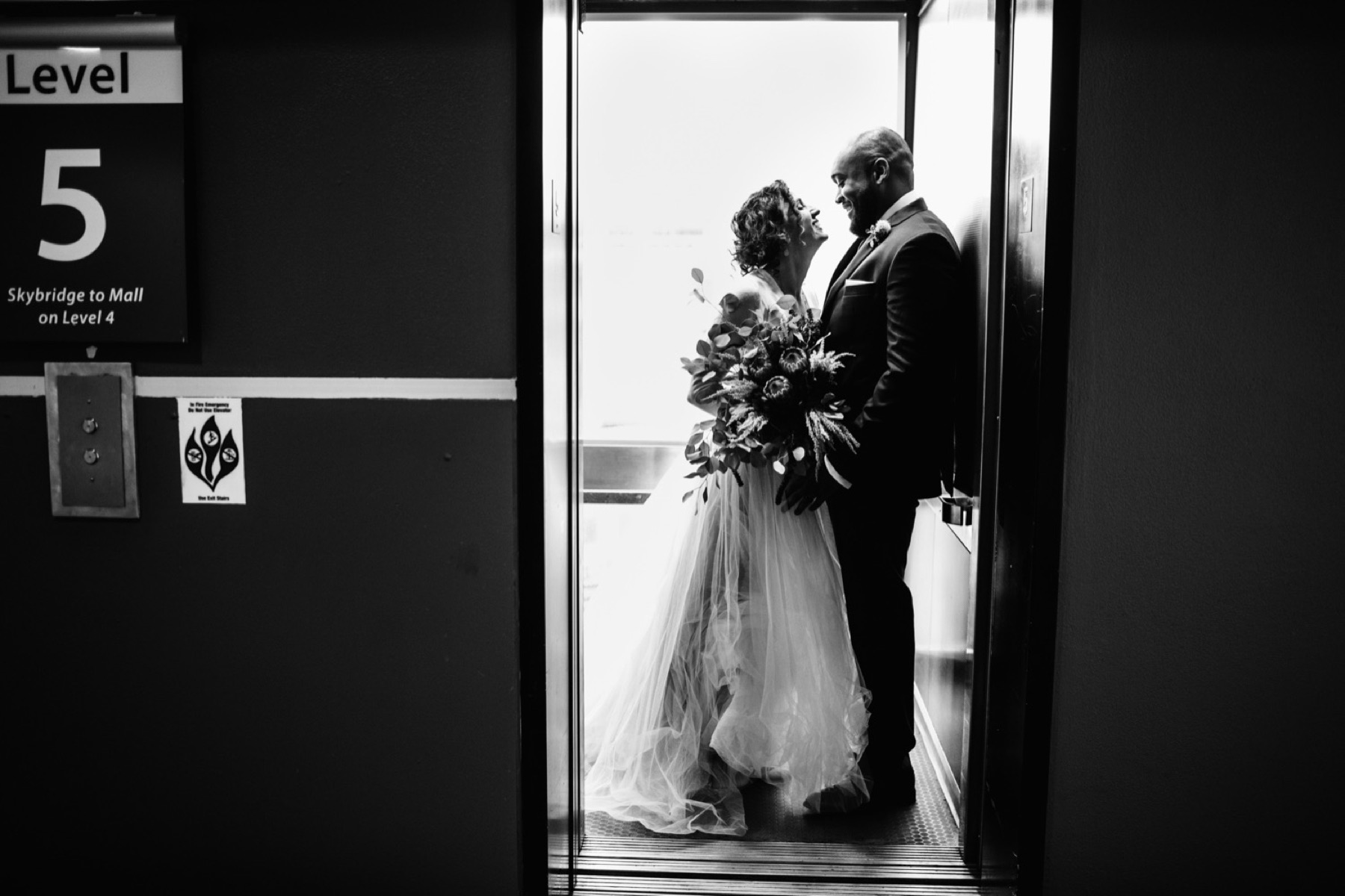 bride and groom kiss in an elevator