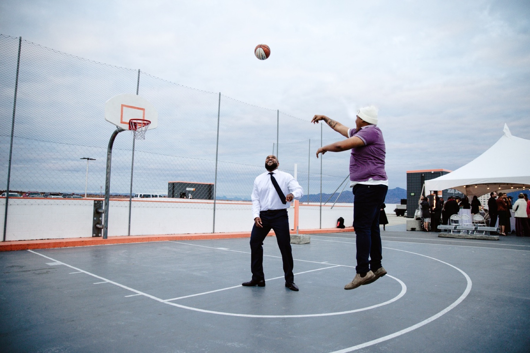 groom shoots basketball with friend on roof of easy park garage