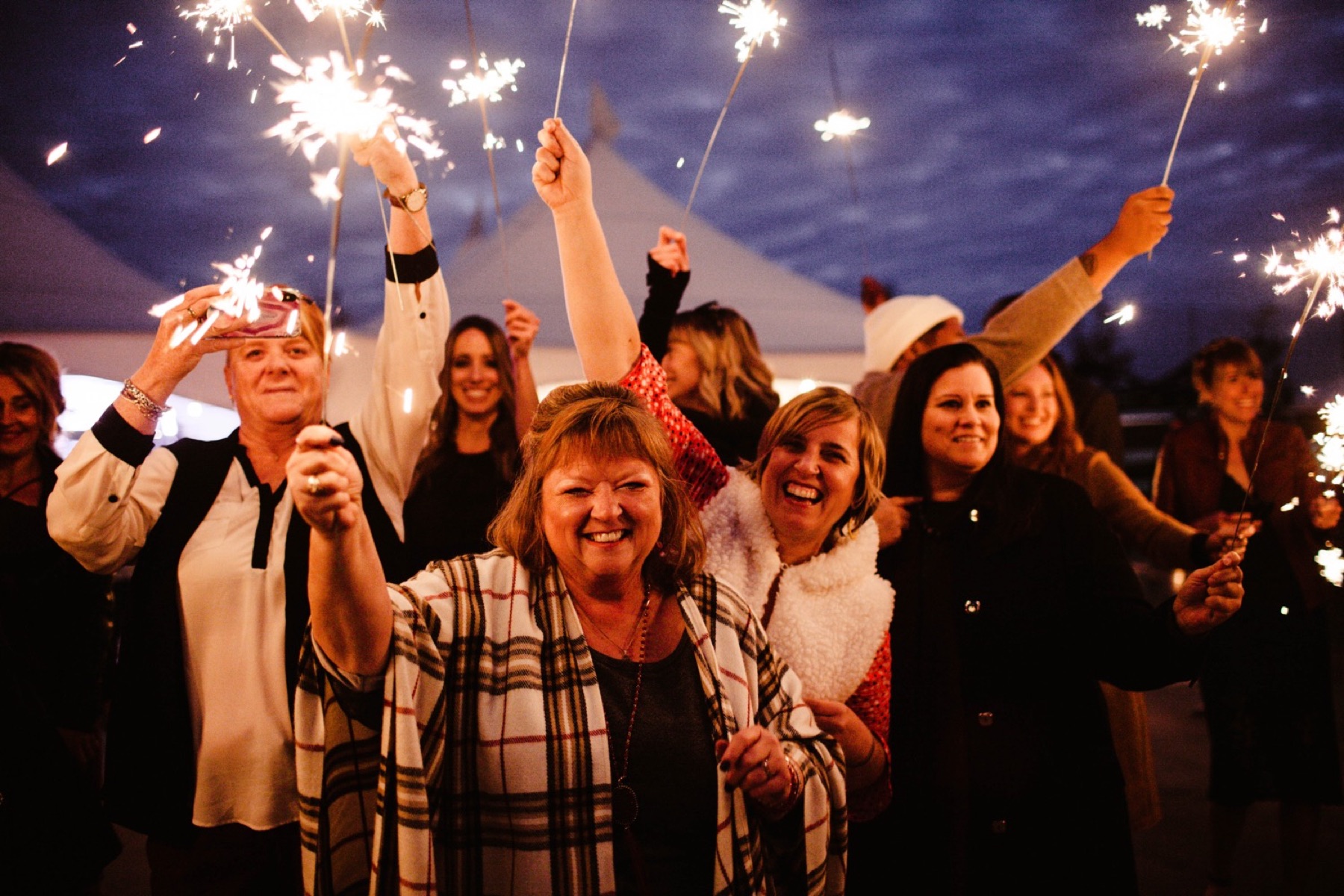 guests wave sparklers in the air at wedding reception