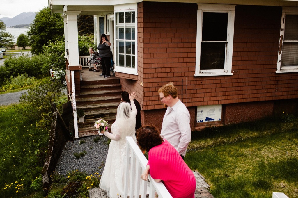 couple waves to neighbors as they wave goodbye from their seward wedding ceremony