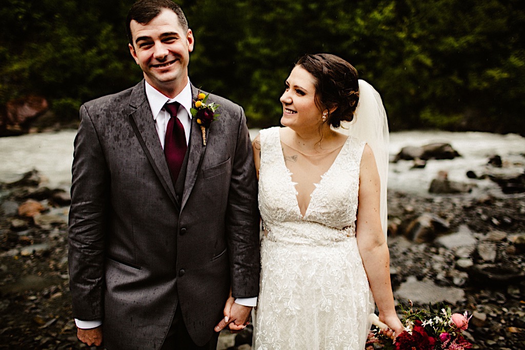 bride and groom smiling in the rain at crow creek 