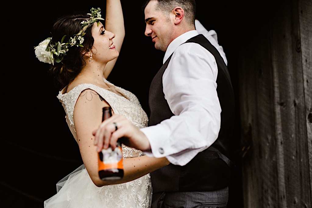 wedding couple laughing with beer in hand