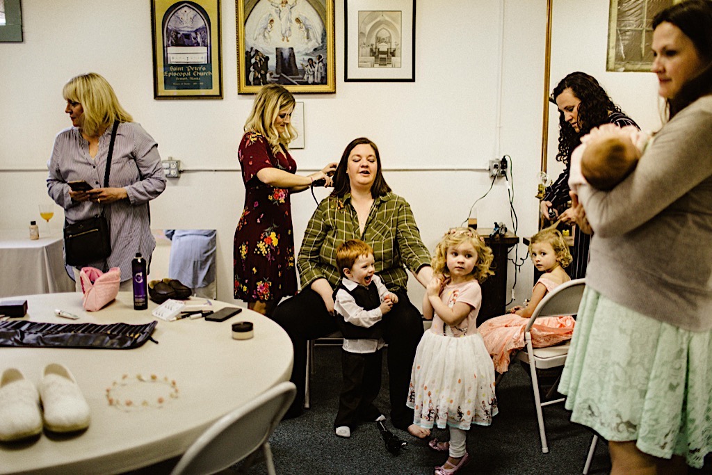 bride surrounded by children getting ready 