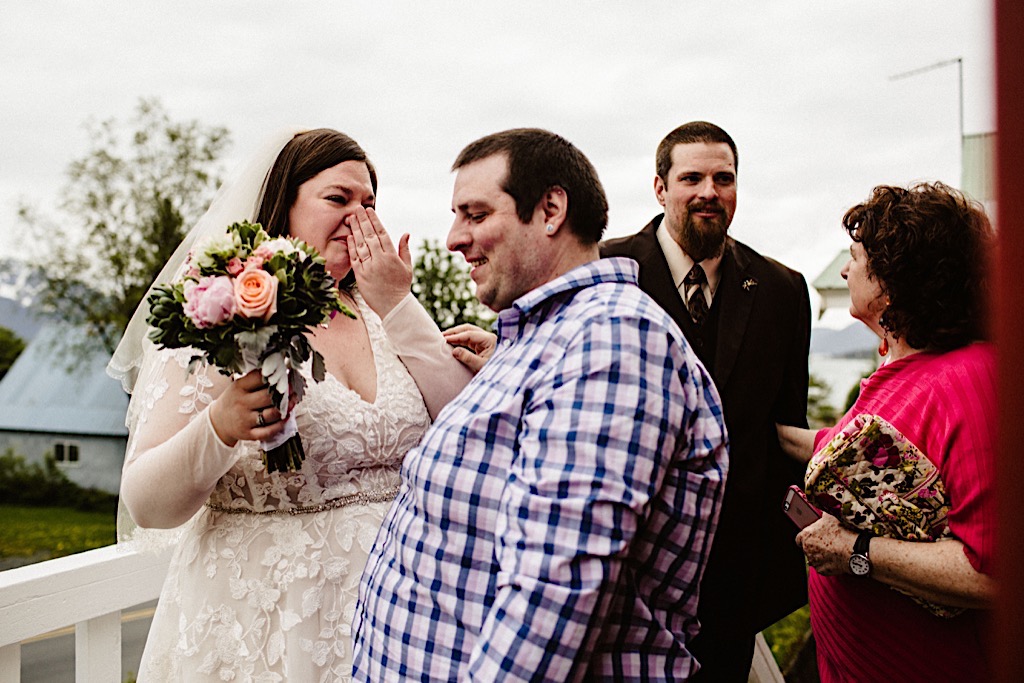 bride holds back tears hugging guests 