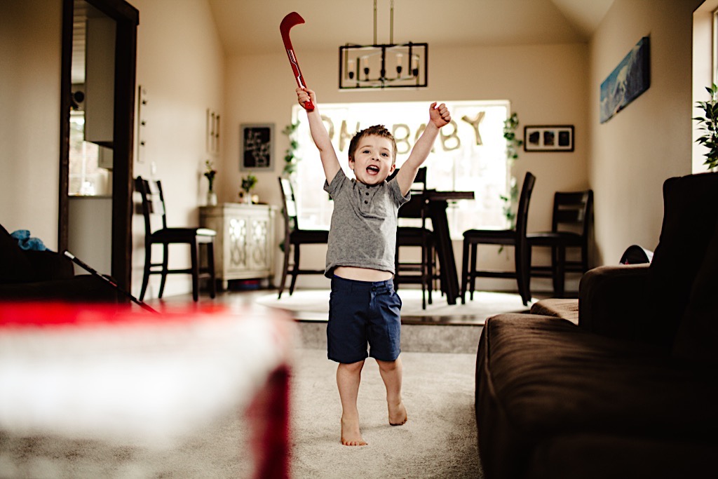 little boy cheering with hockey stick 