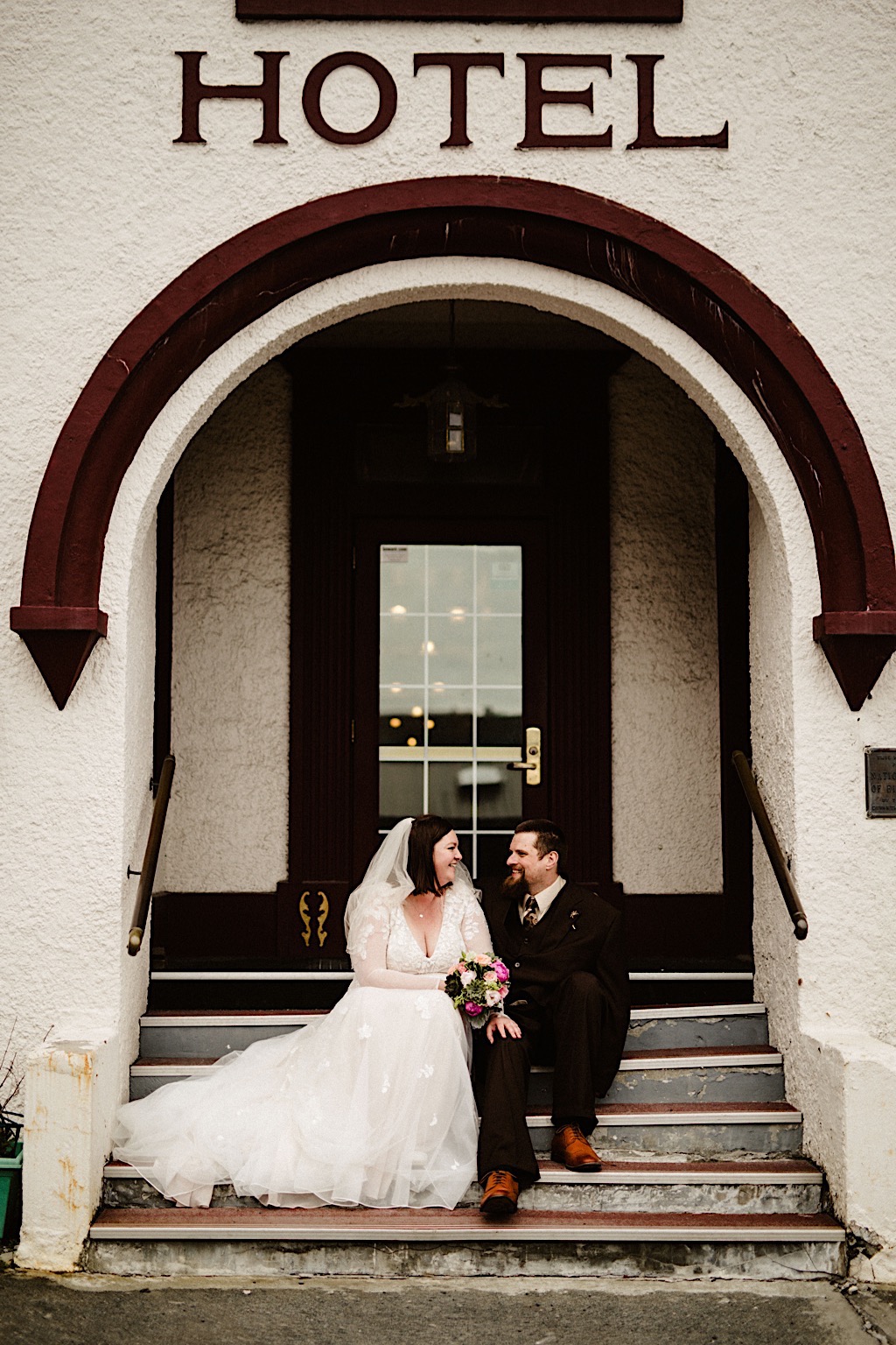 bride and groom on steps of hotel in downtown seward 