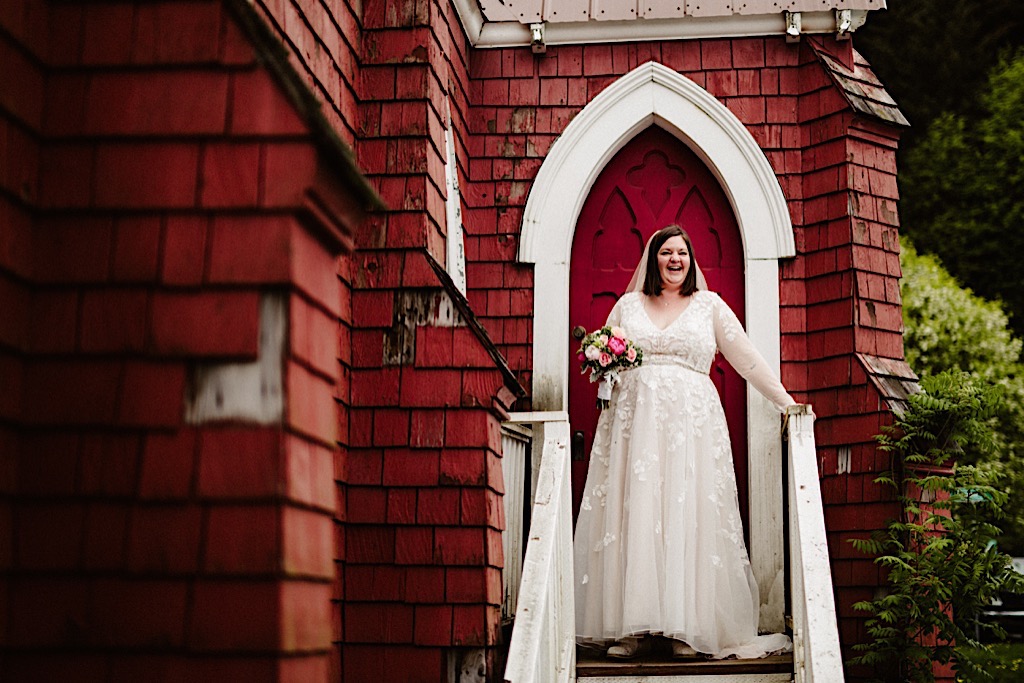 laughing bride in front of red church in seward 