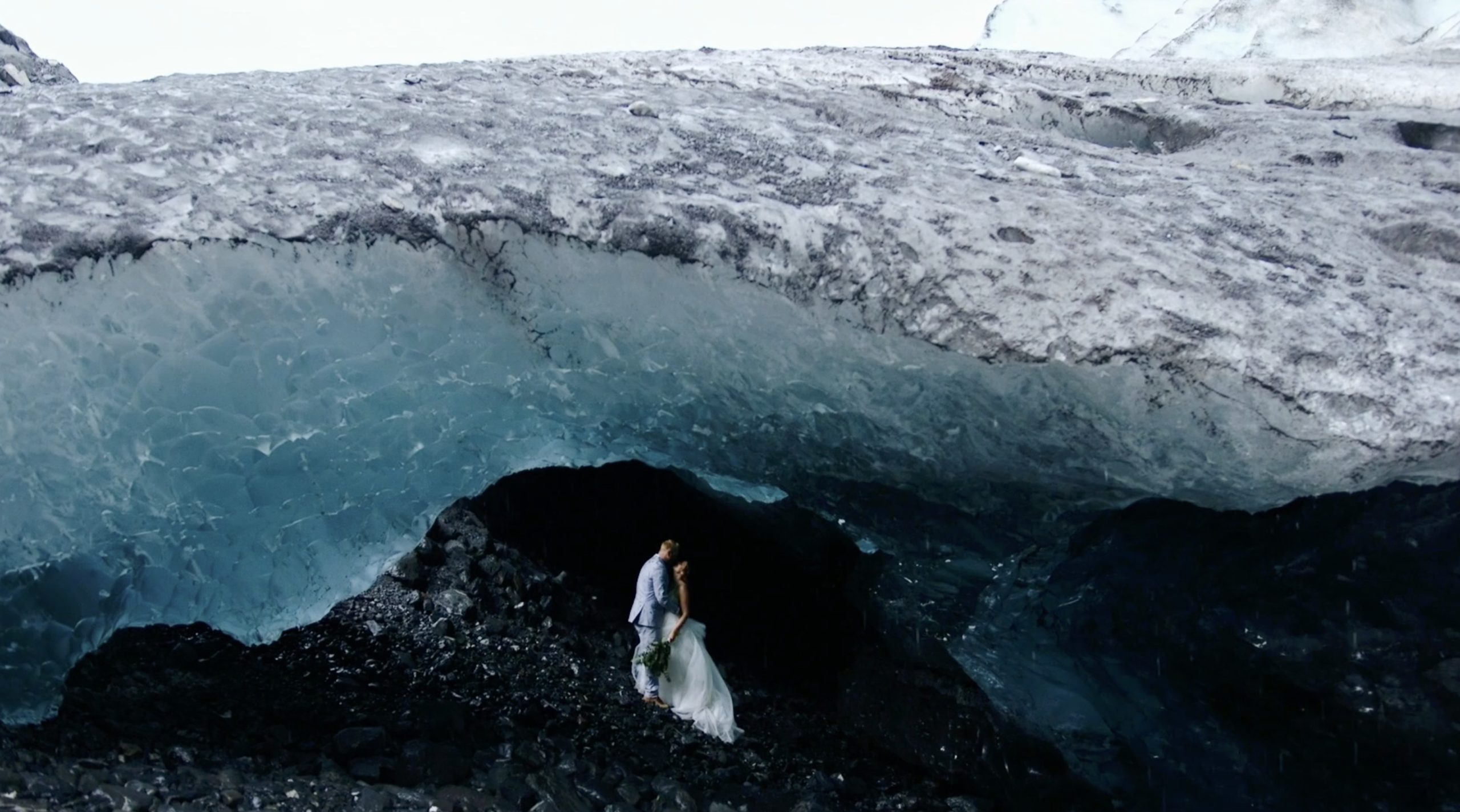 couple standing in ice cave alaska