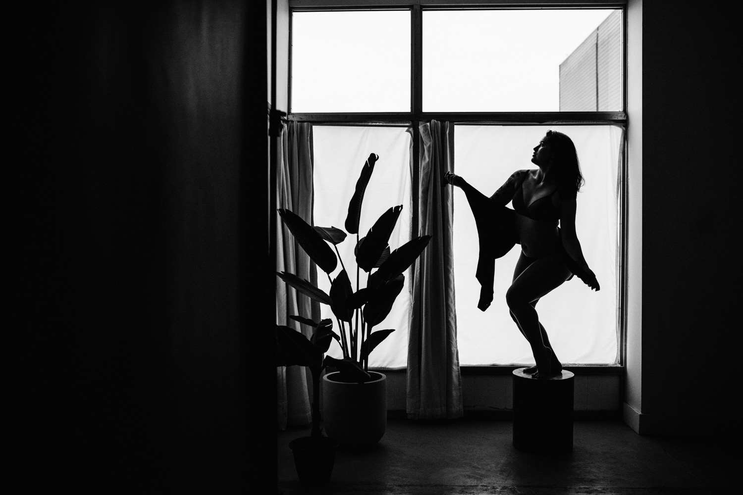 silhouetted woman in front of windows