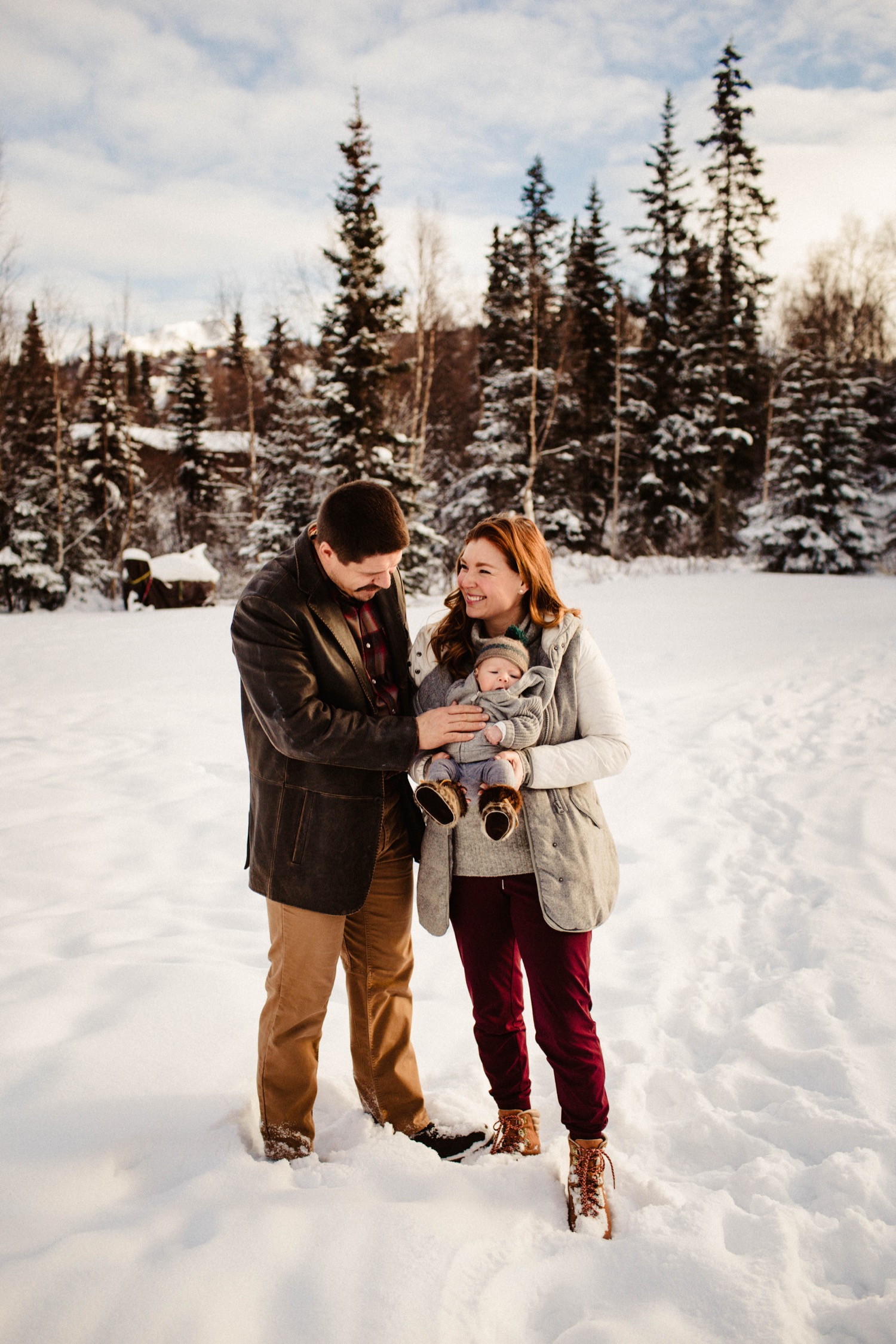 alaskan family outside in snow with newborn baby