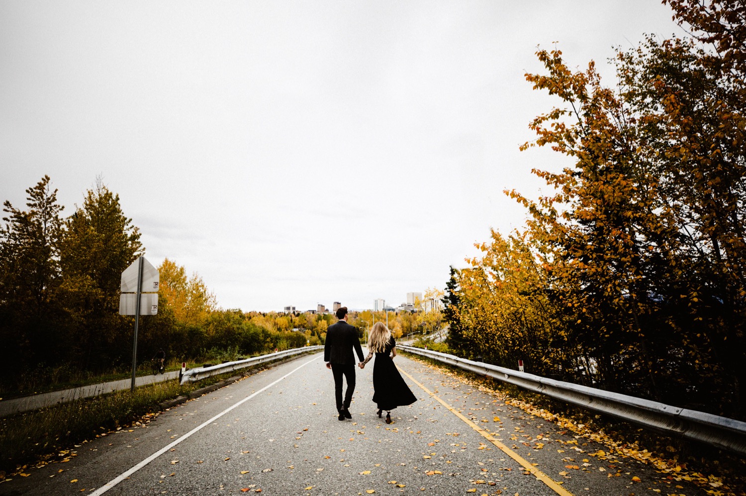 bride and groom walking down west high hill in anchorage