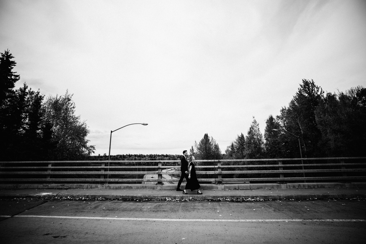 bride and groom walking along overpass