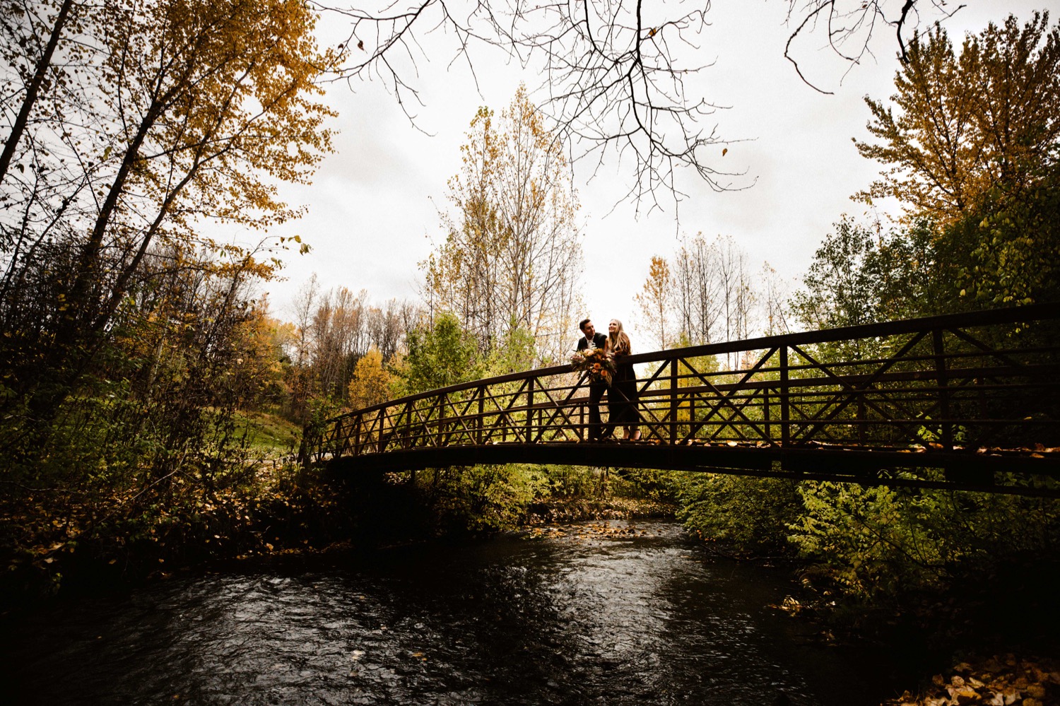 alaska bride and groom on chester creek trail bridge