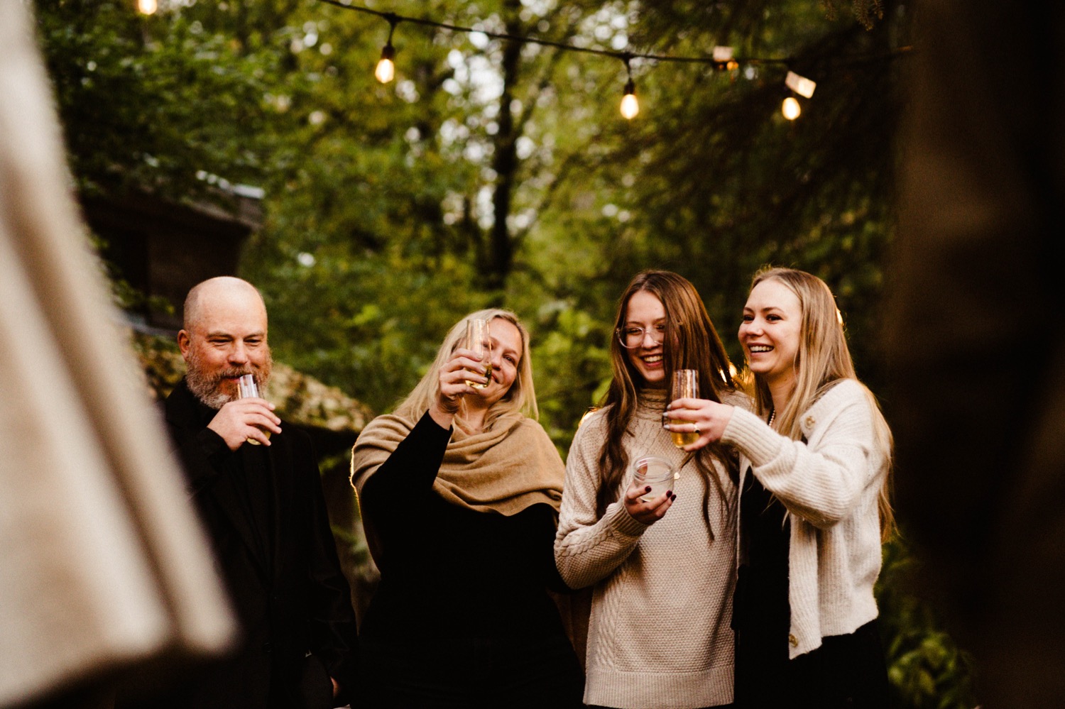 bride shares a toast with her family at backyard wedding in anchorage