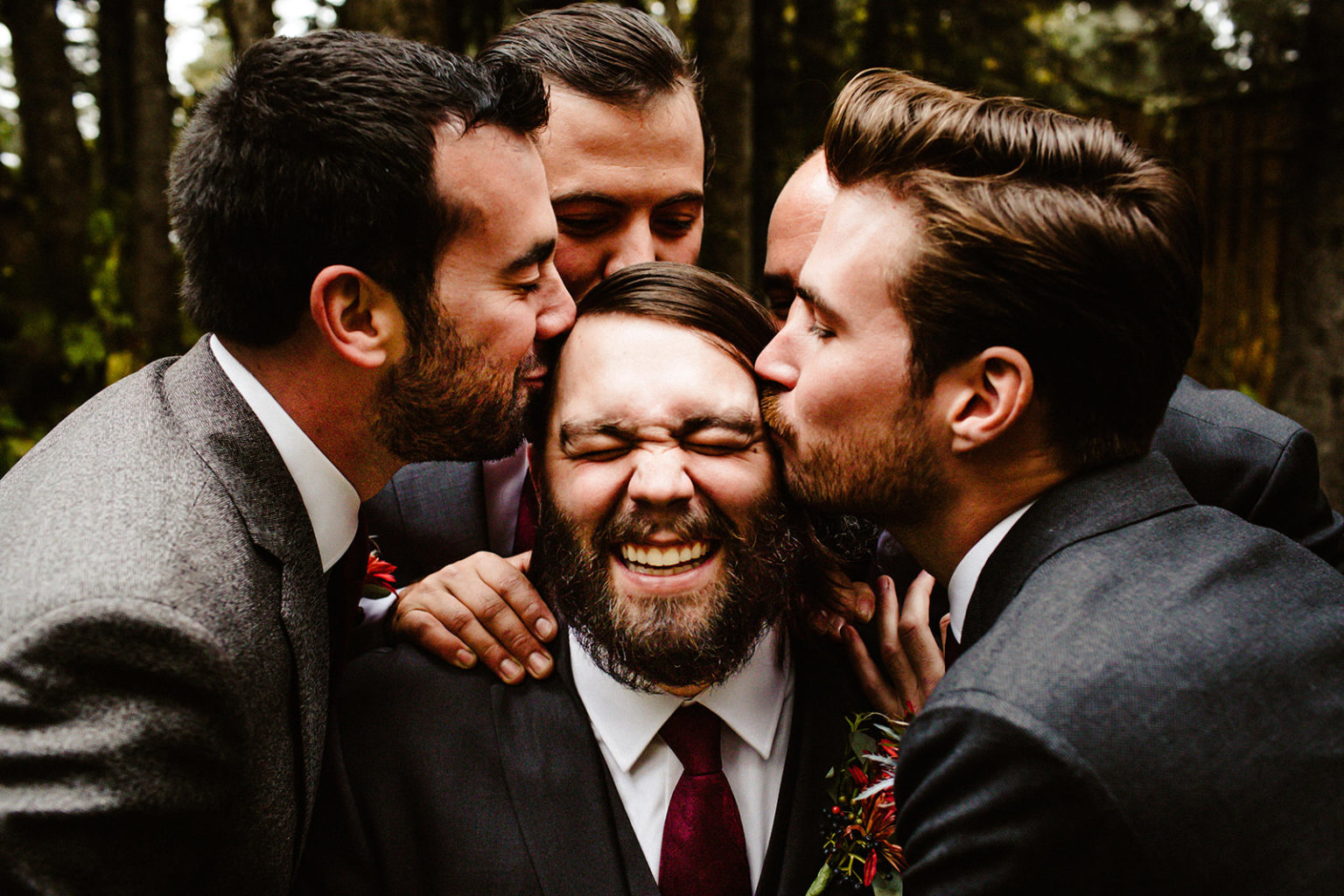 groomsmen kiss groom on face
