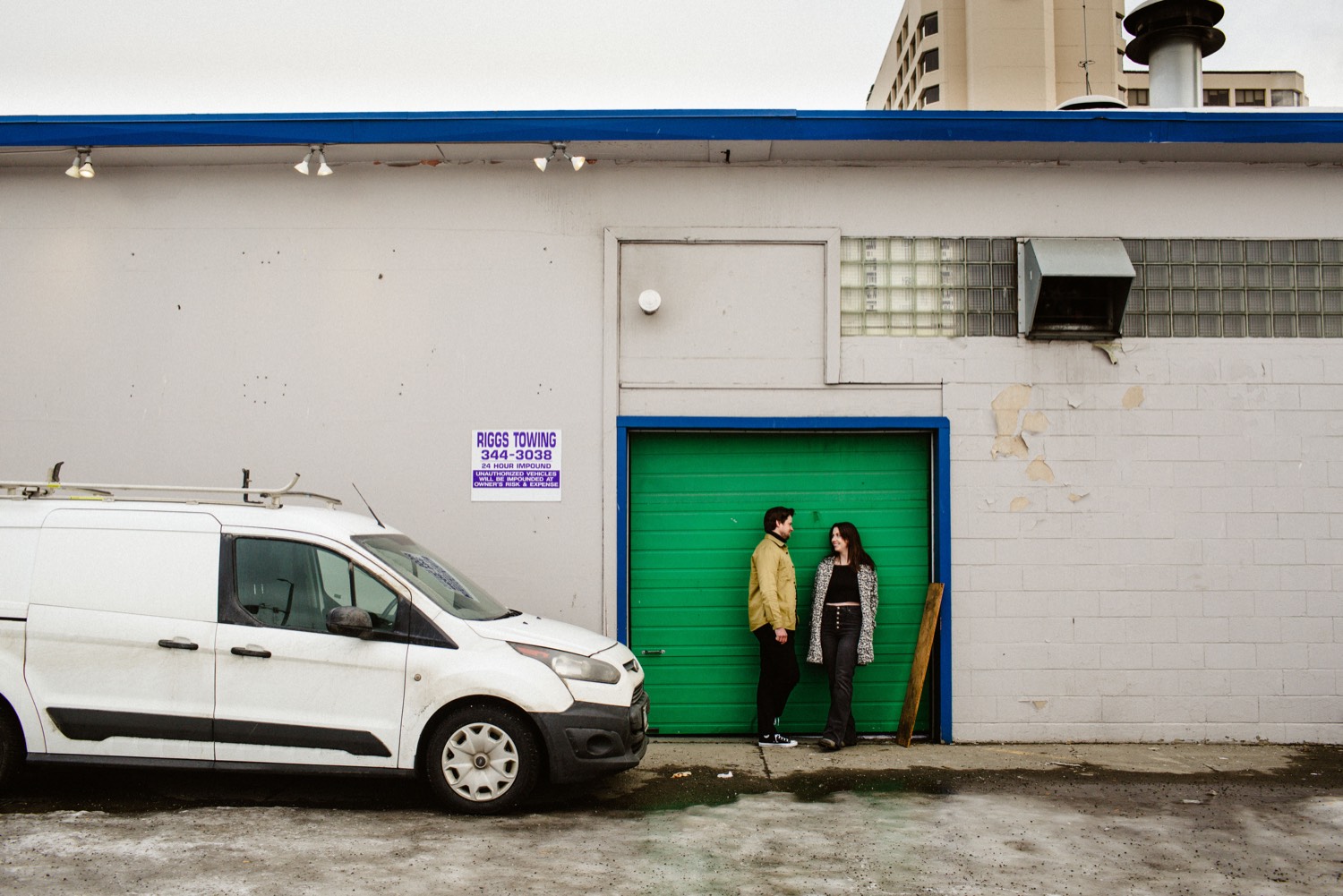 couple standing in front of green garage door
